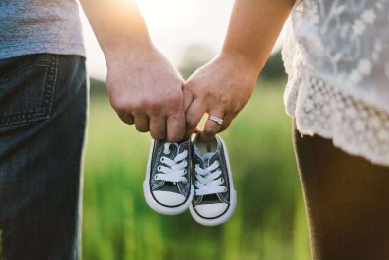 夫婦で子供の靴をもつ家族イメージ